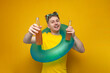 young happy guy in the summer on vacation holds bottles of beer and smiles on a yellow background