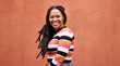 © Lumeez/peopleimages.com - Portrait, wall and black woman with smile, fashion and freedom with joy, success and casual outfit. Face, Jamaican female and happy lady on background, happiness and cheerful with wonder and mockup