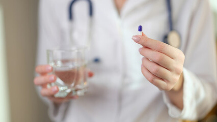 Poster - Doctor holds pill in one hand and glass of water in other.