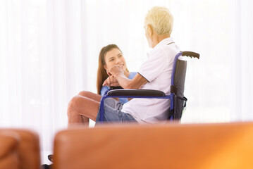 Senior men sitting on wheelchair with nurse take care in a nursing home