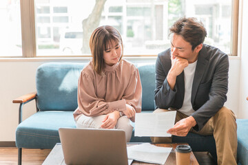 Canvas Print - 書類・資料を見ながらカフェでミーティング・相談するアジア人の男女（夫婦・カップル・ビジネス）
