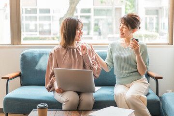 Canvas Print - オフィス・カフェでパソコンを使いながらミーティング・打ち合わせするビジネスウーマン（相談・笑顔）
