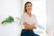 © Jacob Lund - Smiling businesswoman sitting with her arms crossed