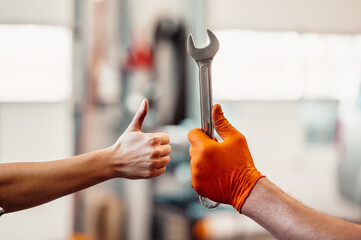 Wall Mural - Mechanic working on a vehicle in a car service. inspection of the car by a mechanic. Repair default. mechanic holds car keys to repair engine part