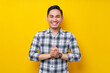 © Bangun Stock Photo - Smiling Young Asian man in casual clothes keeps hands together feels confident isolated on yellow background. People lifestyle concept