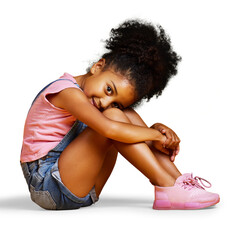 A mixed race young girl looking at the camera sitting and looking carefree in casual clothes isolated on a PNG background.