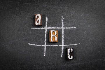 Wall Mural - Letters of the alphabet and game of tic tac on a chalk board