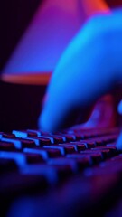 vertical video, male hands rapidly typing on a computer keyboard in smoky neon lighting. unrecogniza