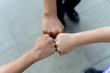 © jittawit.21 - Close up of students standing hands making fist bump gesture.