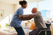 © Westend61 - Physical therapist helping senior man in getting up from wheelchair at home