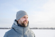 Happy man wearing knit hat in winter under sky