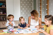 © Cavan Images - Mom with young children drawing with felt-tip pens