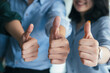 © Cavan Images - Closeup gruop of business people giving thumbs up