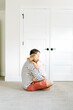 © Cavan Images - Side view of a father comforting a young daughter in a modern home