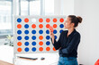 © Westend61 - Thoughtful businesswoman standing by connect four game rack in office