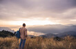 © Westend61 - Mature man with backpack standing on mountain at sunset