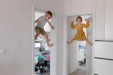 Children Climbing Doorway At Home