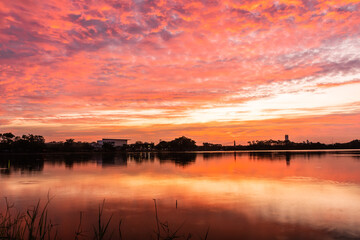 Wall Mural - sunset nearly fall from the sky on the horizon reflected into the water