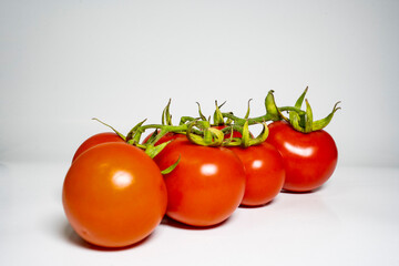 fresh tomatoes branch isolated on white background with tasty and healthy food flat lay side view