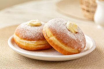 Canvas Print - Close-up of Krapfen or berliner, or doughnut, or bombolone with cream filling, sugar powdered.