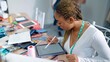 © M Stocker - African american woman fashion designer using tablet drewing pattern for design the clothes at garment shop