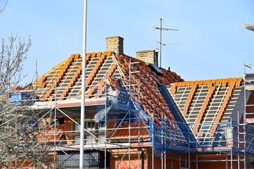 red roof tiles piled on roof renovation