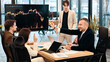 © frimufilms - Young worker leading business meeting in an office, discussing the topic of cryptocurrencies with other workers using a big display with currency rate and physical coin
