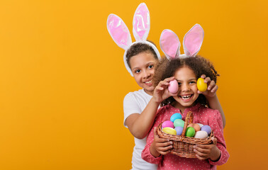 Wall Mural - A happy children with rabbit ears on her head with a basket full of Easter eggs