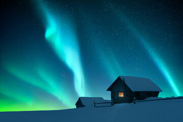 Wall Mural - fantastic winter landscape with wooden house with light in window in snowy mountains and northen lig