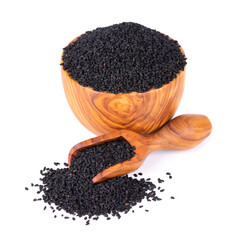 Wall Mural - Black cumin seeds in wooden bowl and spoon, isolated on white background. Heap of black nigella seeds. Nigella sativa.