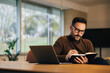 © bnenin - Focused male employer taking notes, witting in front of the laptop at the office.