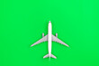 Leinwandbild Motiv White plane, airplane on a green background, flat lay.