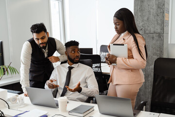 Young multiracial people in business suits working together at office