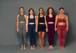 © gpointstudio - Full length portrait of five young women in sports clothes standing and holding hands
