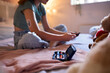 © Monkey Business - Close Up Of Diabetic Girl Sitting On Bed At Home Checking Insulin Levels On Mobile Phone App