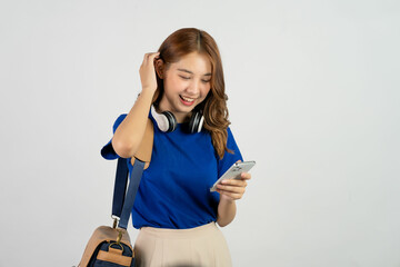 Attractive young asian college student with backpack on shoulder and holding smartphone doing hand pointing gesture on white background