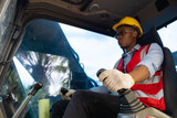 Fototapeta  - Male construction worker operating on Skid tractor or construction vehicle at building site.