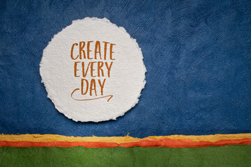 Sticker - create every day - inspirational reminder or advice, handwriting on a circular sheet of watercolor paper against abstract landscape, creativity and personal development concept