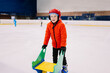 © ADDICTIVE STOCK - Boy skating with special stand on ice rink