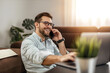 © ivanko80 - Young freelancer is smiling, typing on his laptop in nice modern home