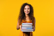 © kohanova1991 - Happy student woman with stack of books from library on yellow background