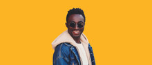 Portrait Of Happy Smiling Young African Man Looking At Camera Wearing Jeans Jacket Isolated On Yellow Background