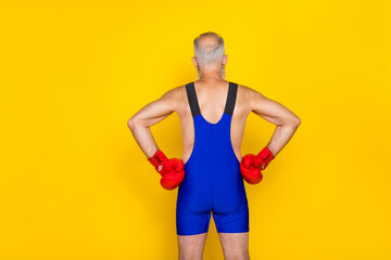 Poster - Photo of back sportive old aged man grandfather grey hair touch waist kickboxer professional training powerful isolated on yellow color background