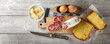 Salami Corallina with cutting board and knife, eggs, Easter cheese cake and parmesan flakes on white wooden background, top view, space for text.
