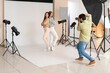 © Pixel-Shot - Male photographer taking picture of beautiful models in studio