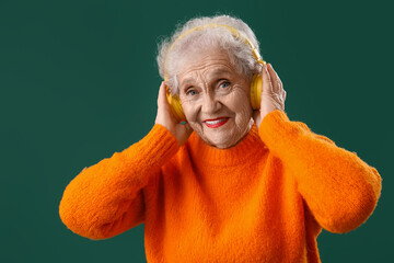 Poster - Senior woman in headphones on green background