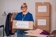 © Zamrznuti tonovi - Portrait of a woman volunteer working in a charity donation center