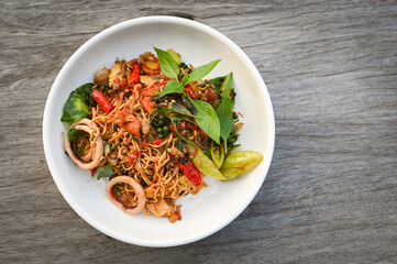 Wall Mural - noodles plate with instant noodles stir fried with vegetables herb spicy tasty appetizing asian noodles mix seafood stir fried squid with basil and chilli pepper - top view