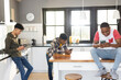 © Wavebreak Media - Diverse teenage male friends sitting in kitchen with smartphones and having fun
