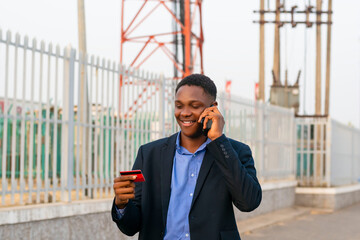 Wall Mural - Businessman using credit card for online banking while communicating on phone